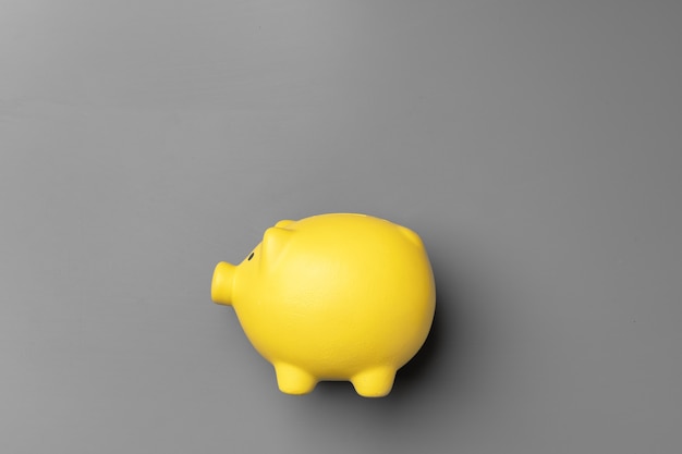 Photo yellow piggy bank on gray surface