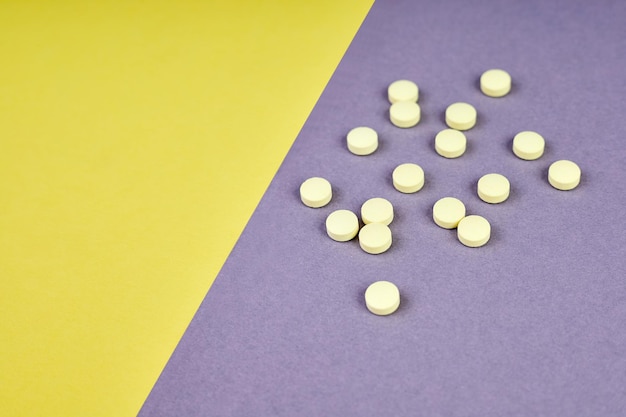 Yellow pills on colorful background