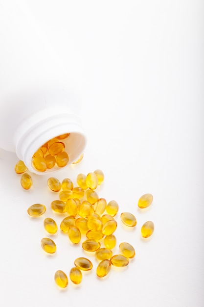 yellow pills coming out from plastic jar