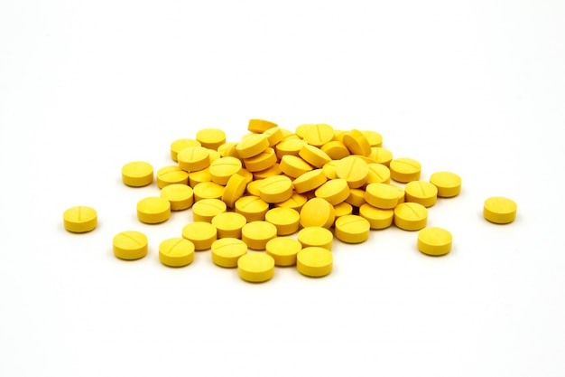 Yellow pills on white background