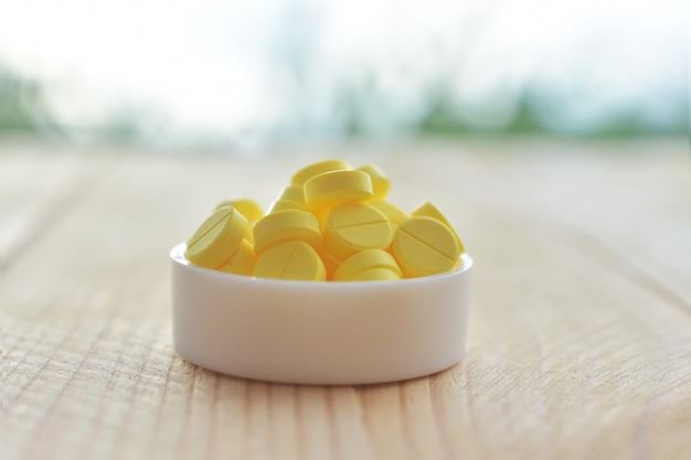 Yellow pills on wood table