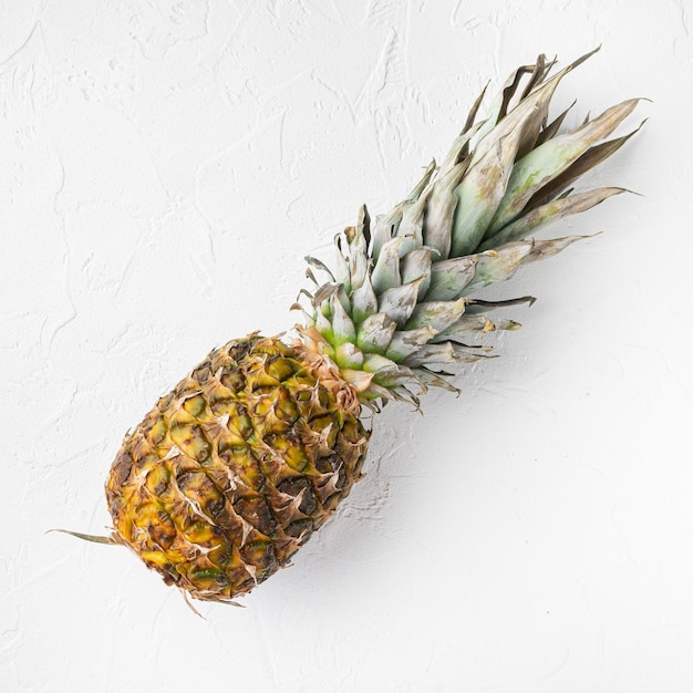 Yellow Pineapple or ananas on white stone table background top view flat lay square format