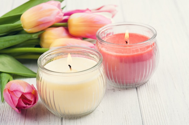 Yellow and pink aroma candles with tulips 