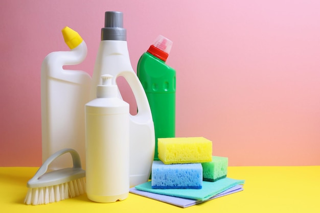 a yellow and pink background with cleaning products and a bottle of soap.