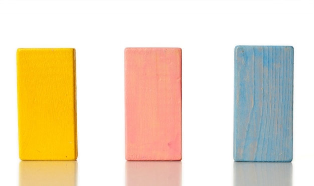 Foto blocchi di legno gialli, rosa e blu isolati su priorità bassa bianca
