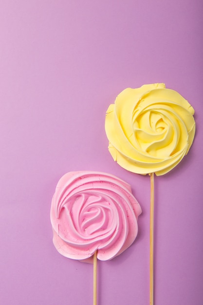 Yellow and pink Rose candy   in pastel colors on a wooden stick on a grey  background