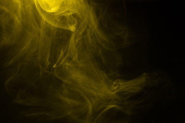 Yellow and pink steam on a black surface. Copy space.