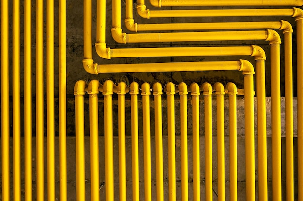 Фото Желтые трубы, соединенные с стеной.