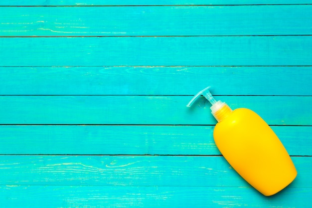 Yellow plastic bottle of sunscreen protection cosmetic lotion on bright background