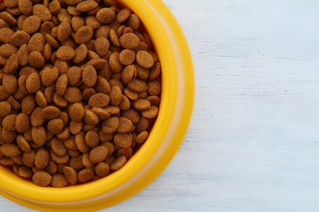 Yellow plastic bowl full with dog food