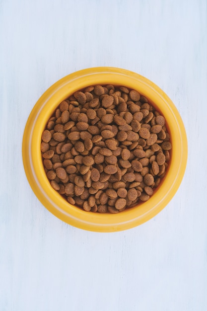 Yellow plastic bowl full with dog food