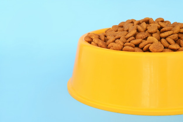 Yellow plastic bowl full with dog food