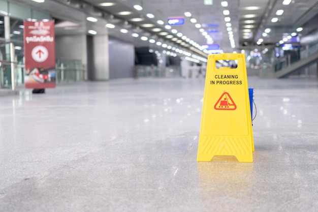 Yellow plastic cone with sign showing warning of wet floor in restaurant in department store