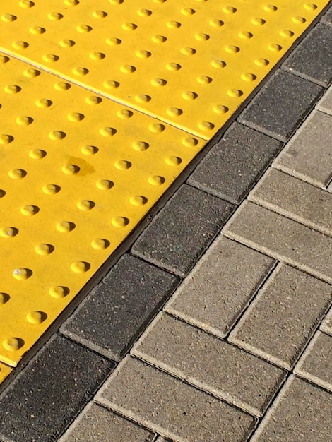 Foto piastrelle di plastica gialle di avvertimento sul bordo della piattaforma ferroviaria