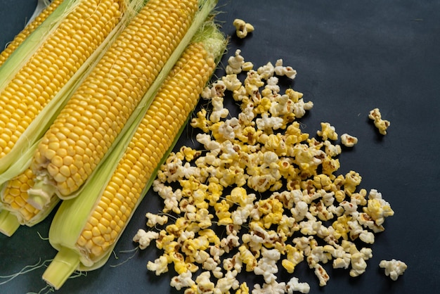 Фото Желтый попкорн и кукурузные початки, сырая кукуруза, соль и сладкий вкус