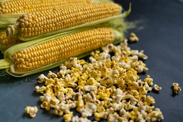 Yellow popcorn and corncobs and raw corn salt and sweet tastes