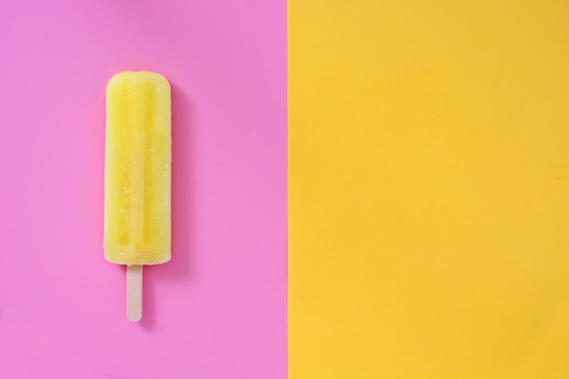 Yellow popsicle on pink and yellow