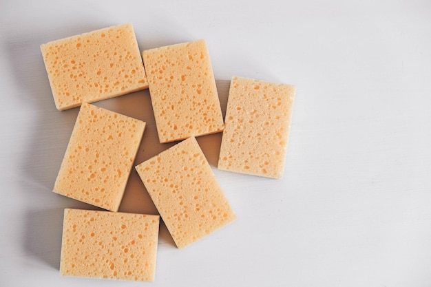 Yellow porous sponges on a white background. Copy, empty space for text