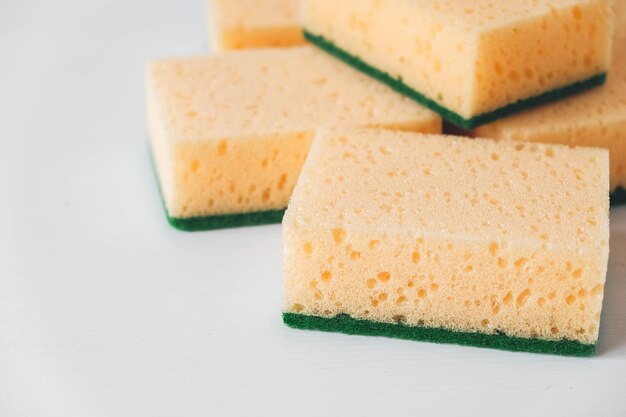 Yellow porous sponges on a white background. top view. copy,\
empty space for text