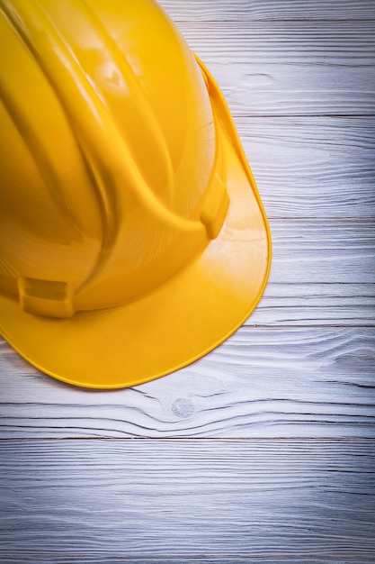 Photo yellow protective building helmet on wooden board construction concept.