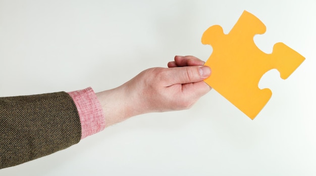 Yellow puzzle piece in male hand