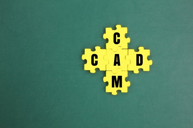 写真 cadとcamの文字が書かれた黄色いパズル ⁇ コンピュータ支援設計とコンピュータ支援製造 ⁇