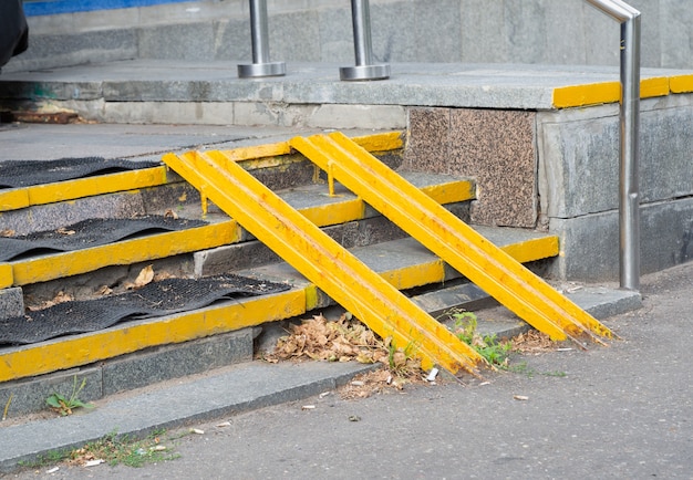 Yellow ramp on the stairs at the entrance of the house for the disabled or a baby carriage