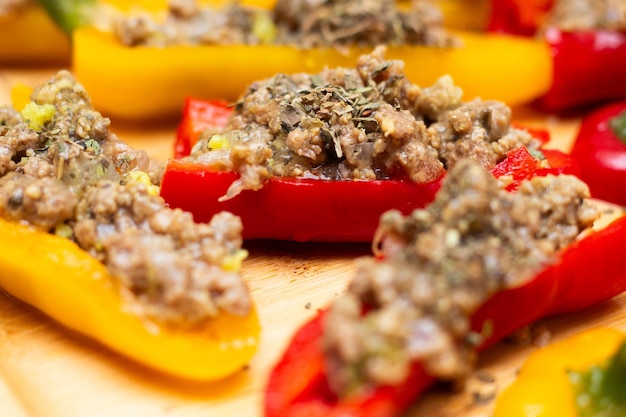 Yellow and red bell peppers with delicious ground beef stuffing on wooden table