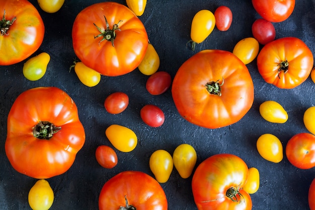 Yellow and red tomatoes on a dark surface