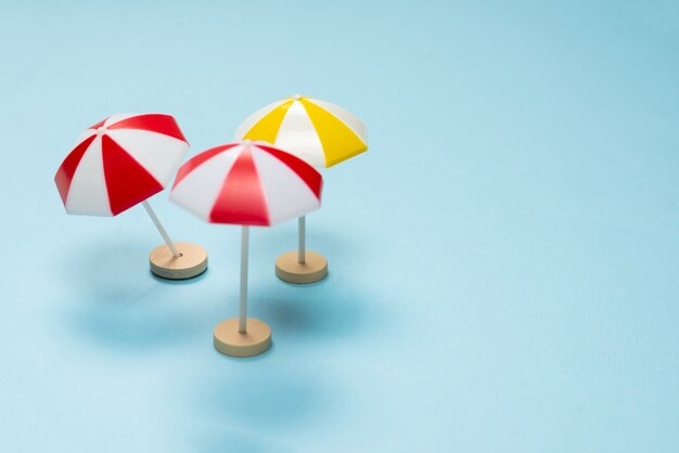 Yellow and red umbrella on a blue background. Copy space.