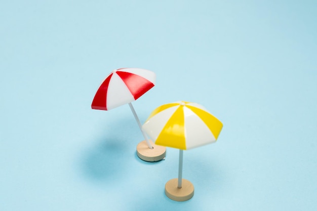 Yellow and red umbrella on a blue background. Copy space.