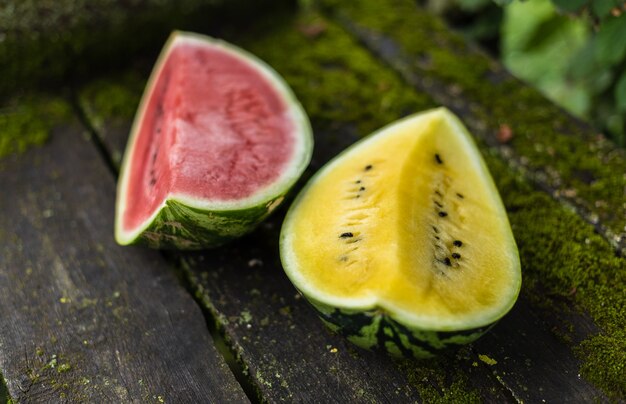 Yellow and red watermelon on an old wooden surface