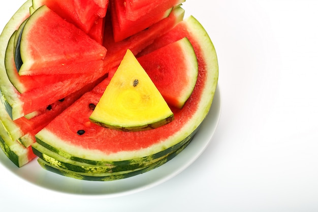 Yellow and red watermelon in a white round plate