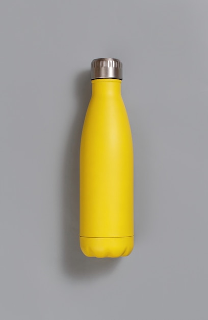 Photo yellow reusable insulated bottle on yellow top view