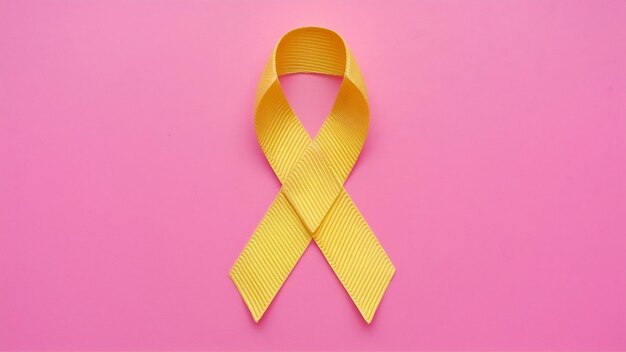 Photo yellow ribbon symbolic color for sarcoma bone cancer on pink backdrop