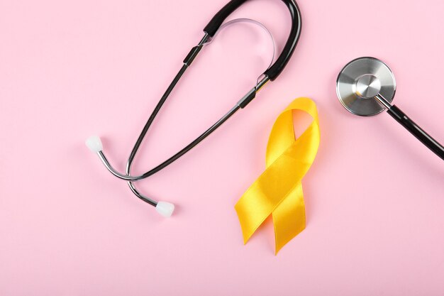 Nastro giallo che simboleggia il cancro nella vista dall'alto dei bambini