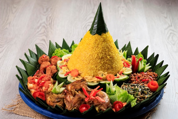 원뿔 모양의 노란 쌀. 인도네시아에서 "Nasi Tumpeng"이라고 불리는 반찬과 함께 축제 인도네시아 쌀 요리