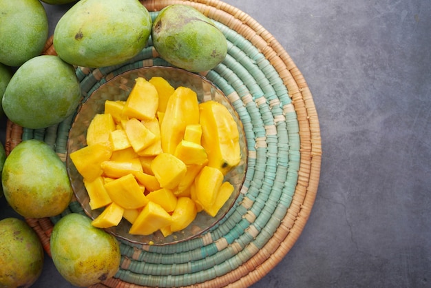 Желтое спелое манго в миске сверху вниз