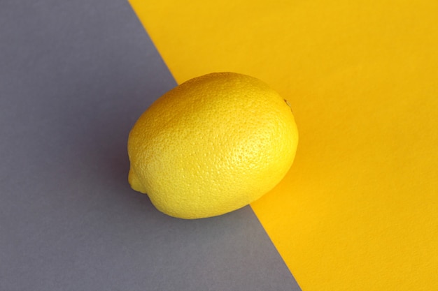 写真 黄色、熟した、酸っぱい、ビタミンフルーツレモンは黄灰色の壁にあります。