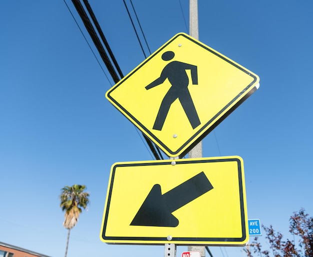 Yellow road sign for pedestrian directing this way