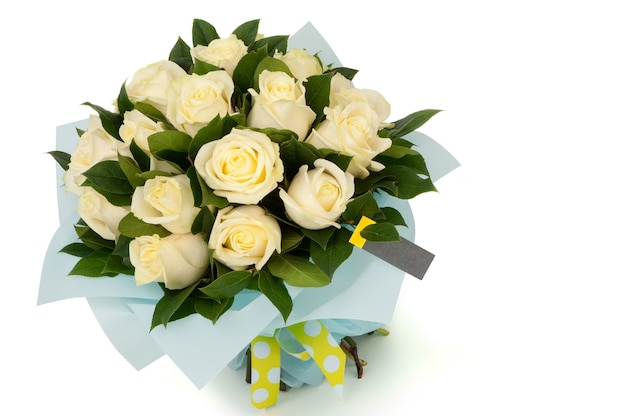 Желтые розы в бумажном букете перевязаны лентой на белом фоне. День святого Валентина
