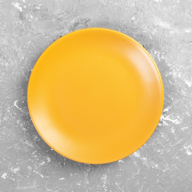 Yellow Round Plate on grey cement table