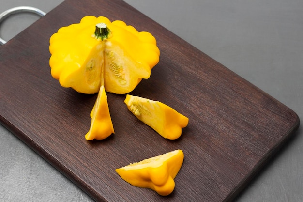 Yellow round zucchini and zucchini slices on a cutting board