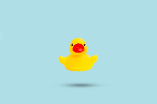 A yellow rubber toy duck floating on a light blue