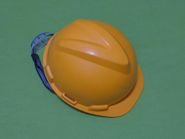 Yellow safety hat on green background