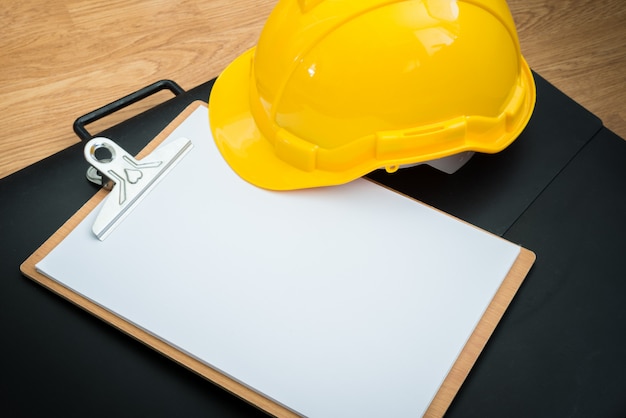 yellow safety helmet hat and clipboard