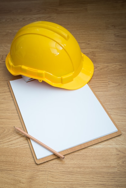yellow safety helmet hat and clipboard