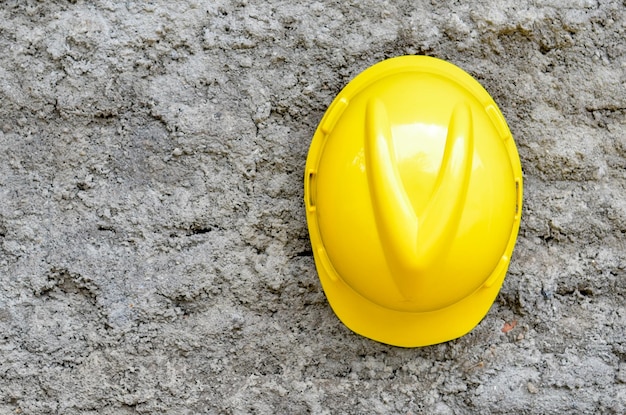 Yellow safety helmet on textured wall