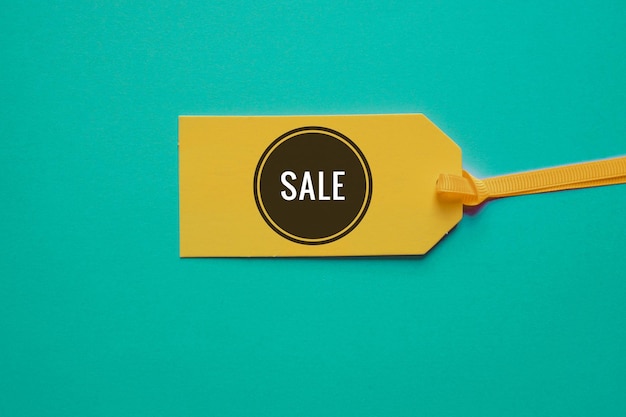 A yellow sale tag with the word sale on it