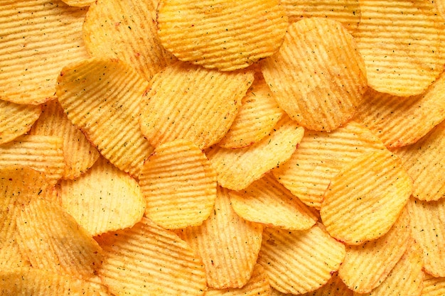 Yellow salted potato chips as background